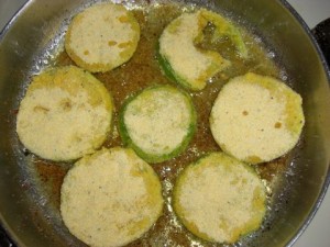 Green tomatoes frying on the first side.