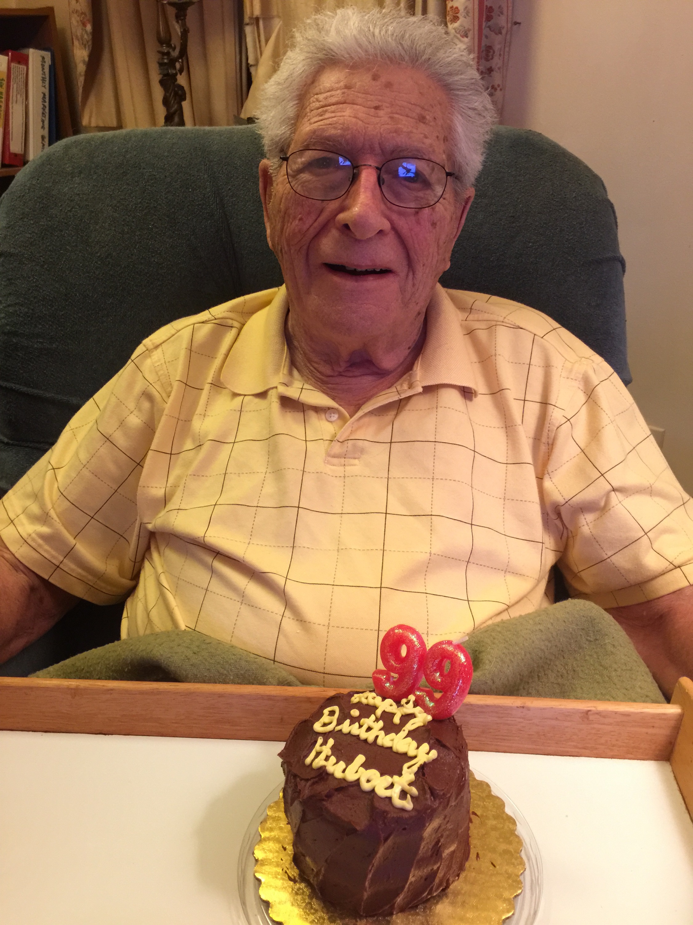 Hubert P. Yockey with a chocolate birthday cake with numeral candles for his 99th birthday.